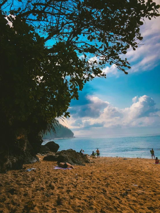 people sitting at the edge of a shore line