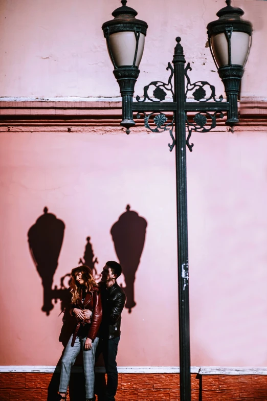 some people standing next to a light pole