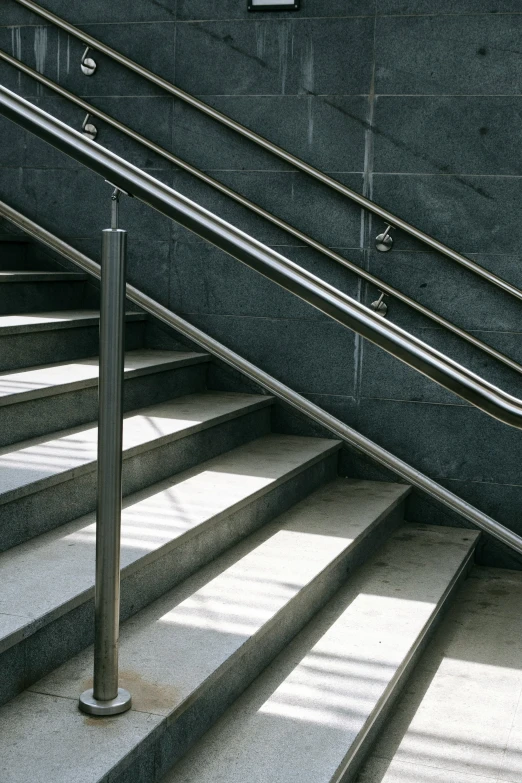 there is a man walking down stairs next to a rail