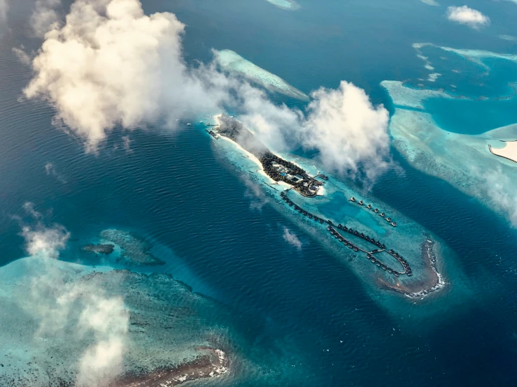 some very pretty islands in the water by some clouds