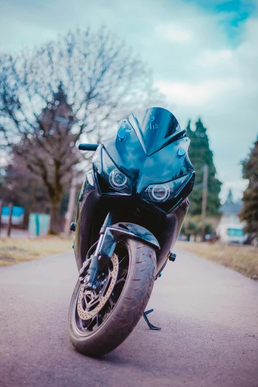 a blue motorcycle is parked on a small road