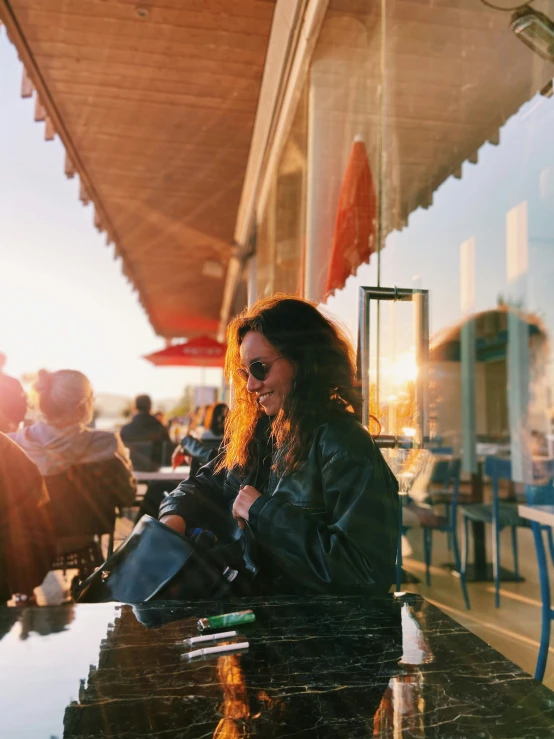 a woman is sitting on the bench with a large black purse