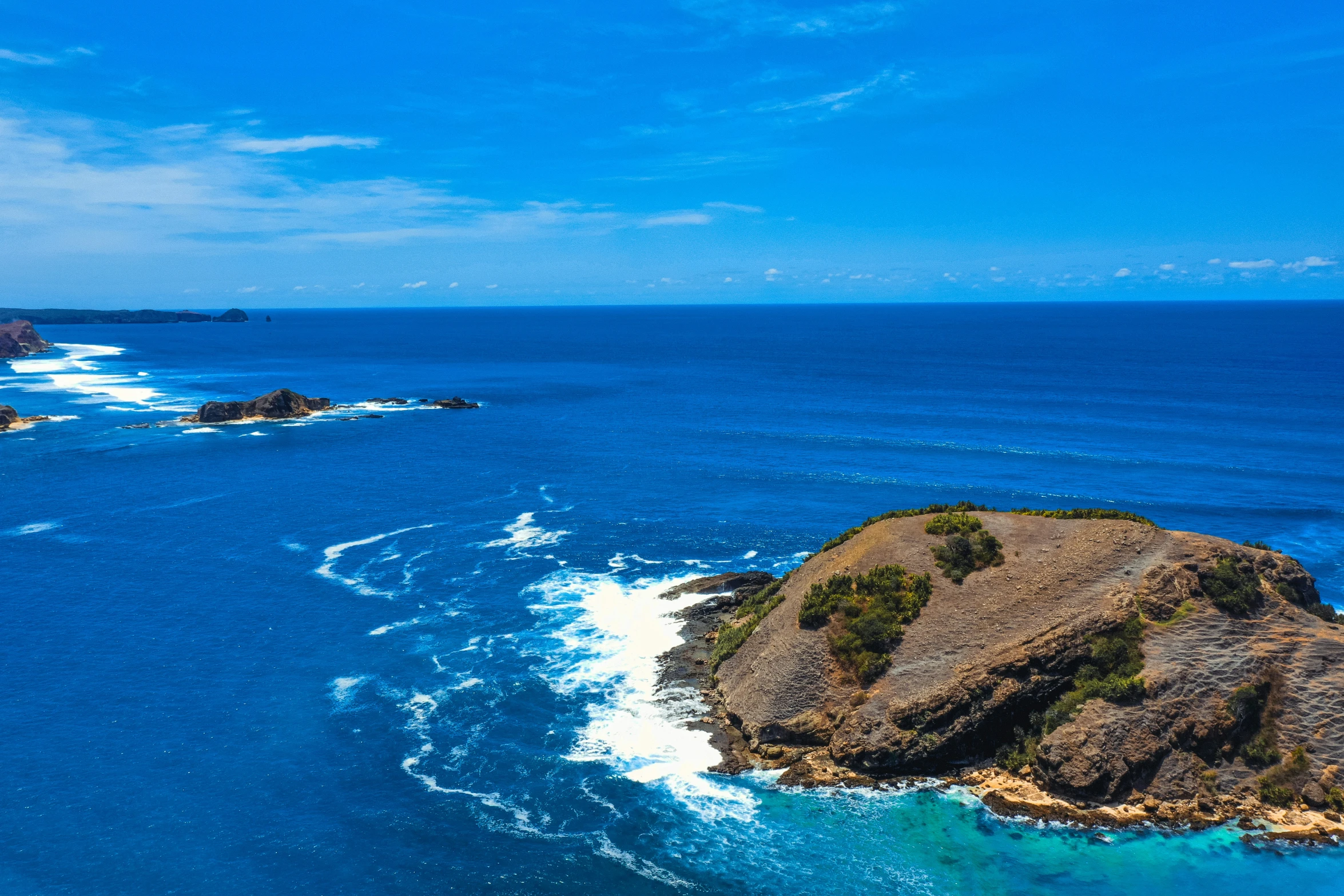 an island is on the ocean in the middle of the day