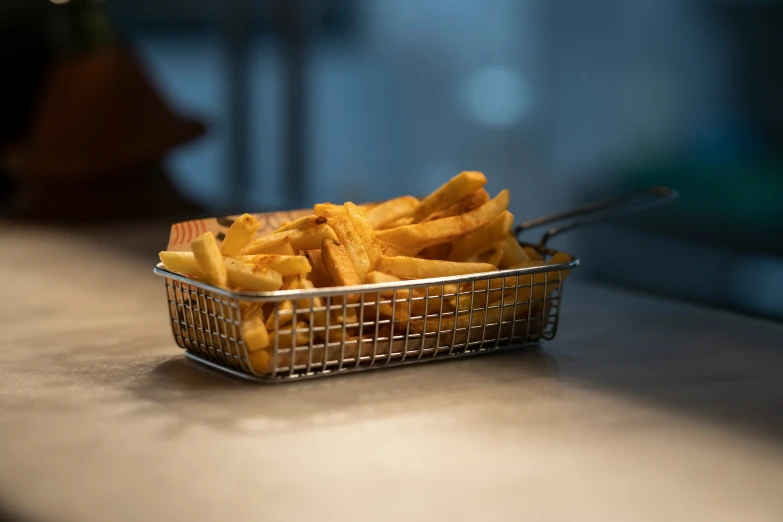 a basket full of fries sitting on top of a counter