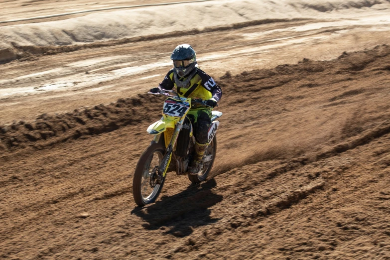 the man is riding his motorcycle down the dirt track