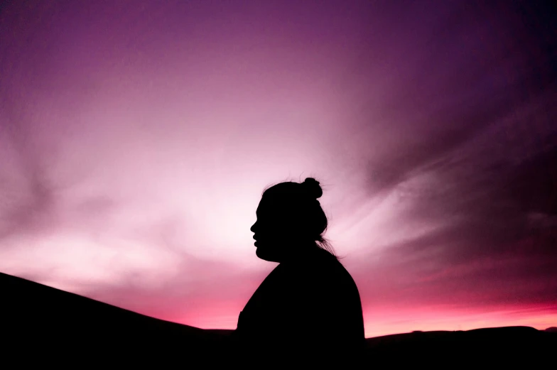 a person silhouetted against the evening sky