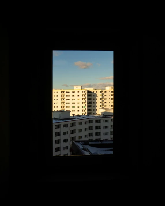 view from inside an open window with buildings in the background