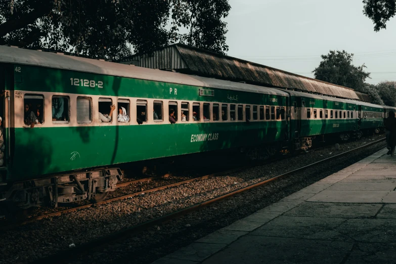 a long green train on a steel track