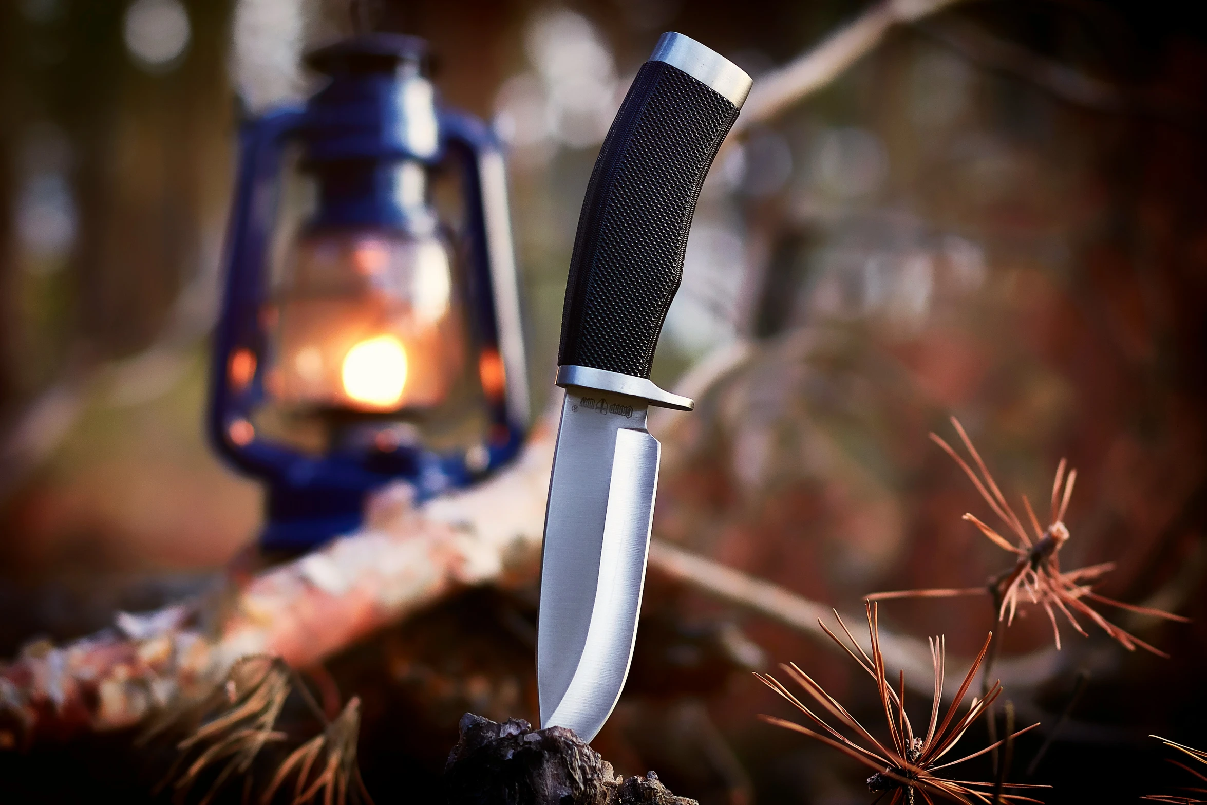 a knife sitting next to a lite up lantern