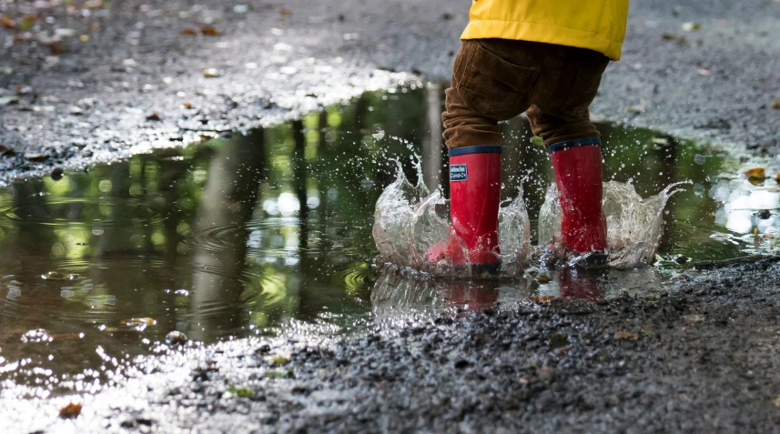 a person standing in the rain with their legs in a dle