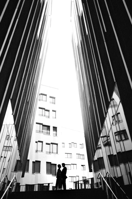 couple walking up steps in front of a very tall building