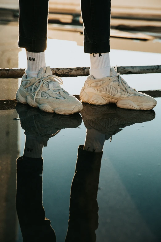 man standing in front of water with a clear shoe on the ground