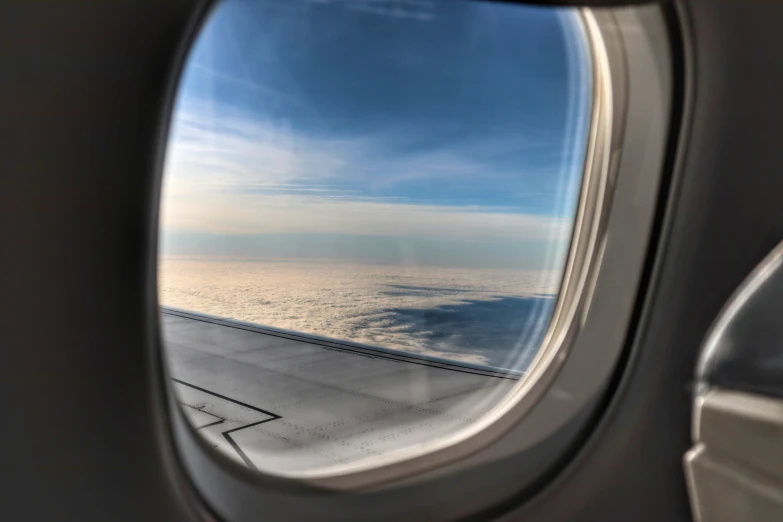 a view of an airplane wing and the ocean outside