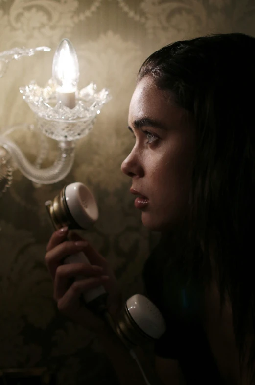 a girl blow drying her hair in front of a candle