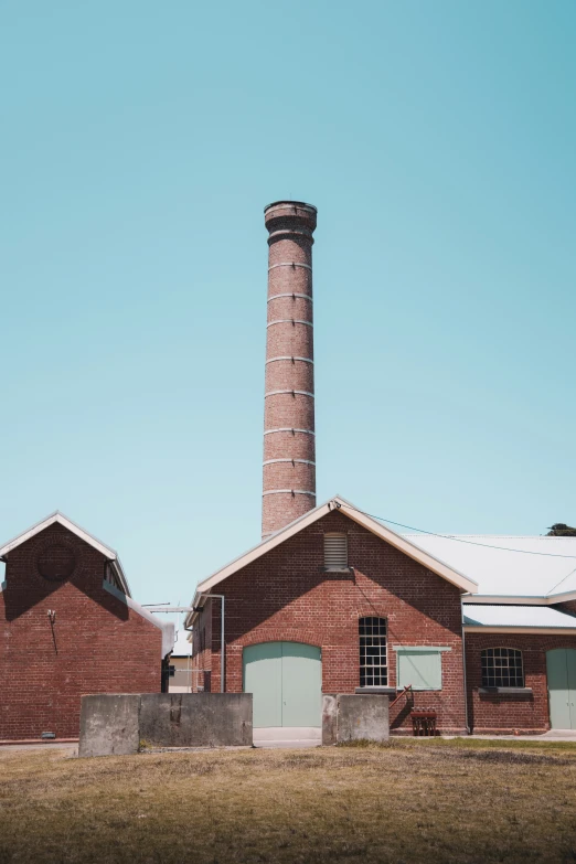 a building with two chimneys and garages behind it