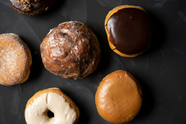 five donuts arranged in a circle on a black surface