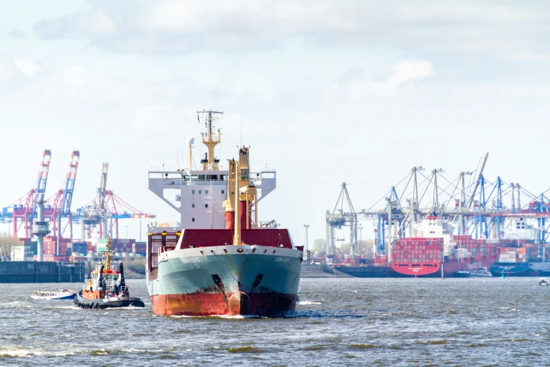 a large cargo ship sailing past a tug boat