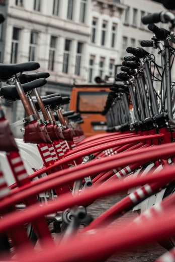 red bicycles are parked in a row by each other