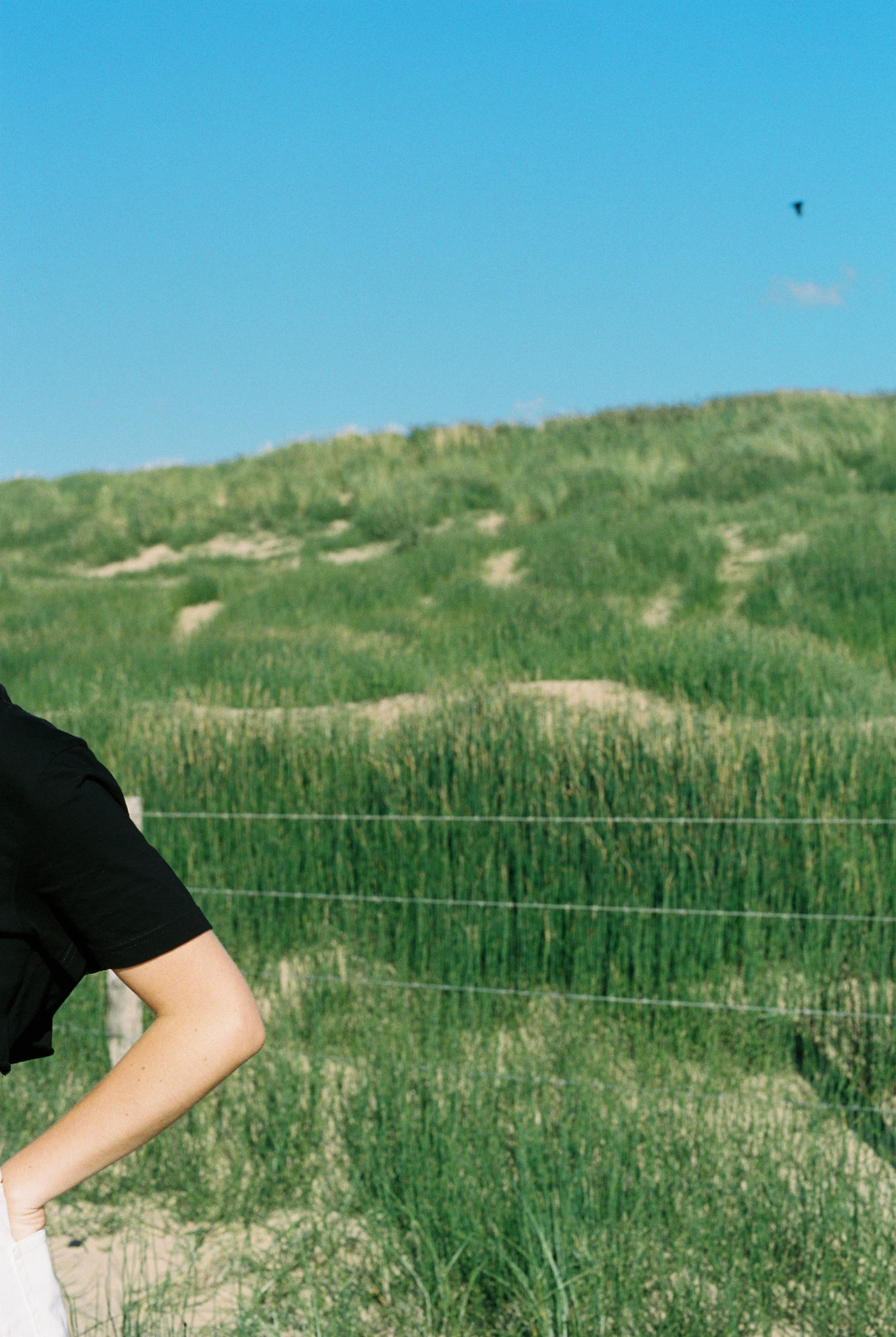 the woman is posing next to a fence