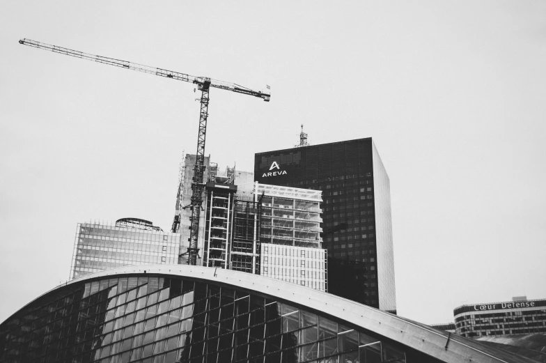 some skyscrs with a crane above and an overpass