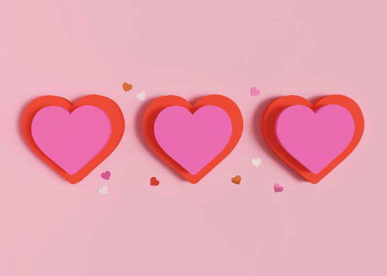 three red heart shaped paper shapes on pink background