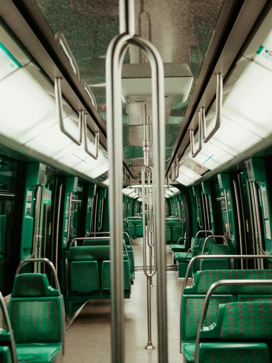 the inside of a commuter train, with its seats and a hand rail