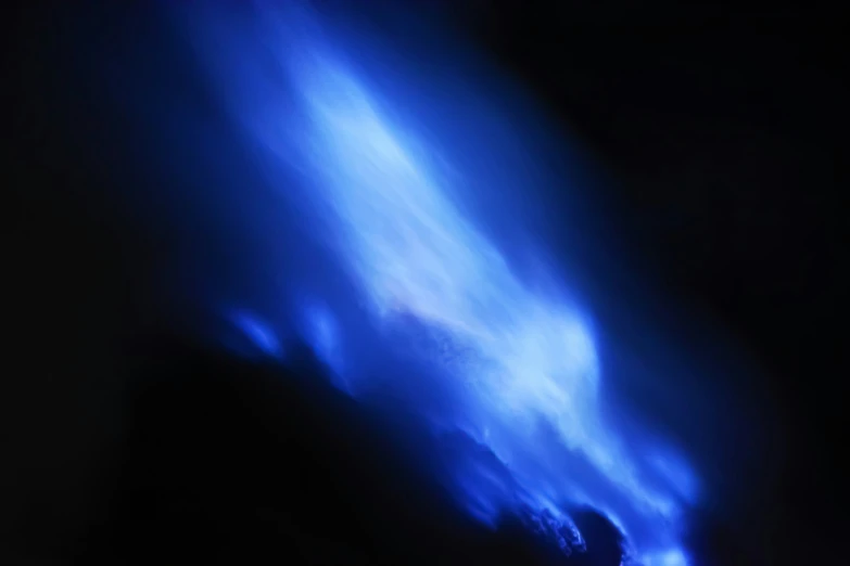 an abstract s of bright blue flame in the night