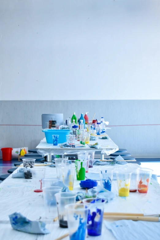 a long table filled with paint and brushes