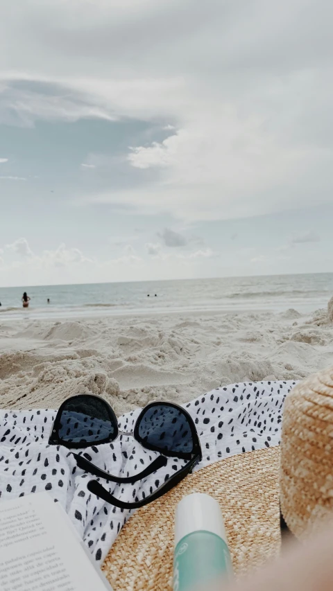 someone's sun glasses and books are lying in the sand