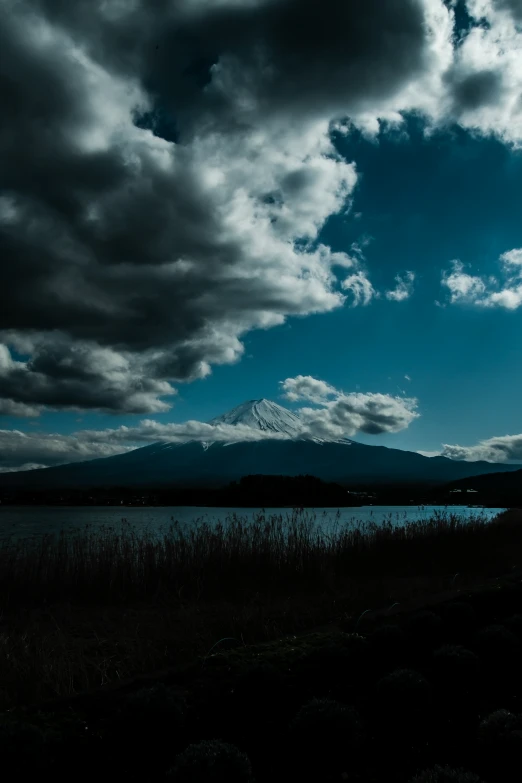 a lake and mountain on a cloudy day