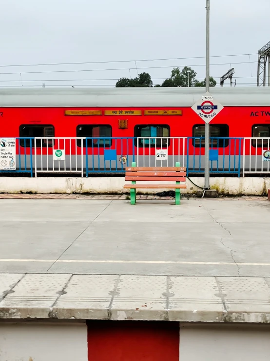 a train sits parked near a rail station with red and blue doors