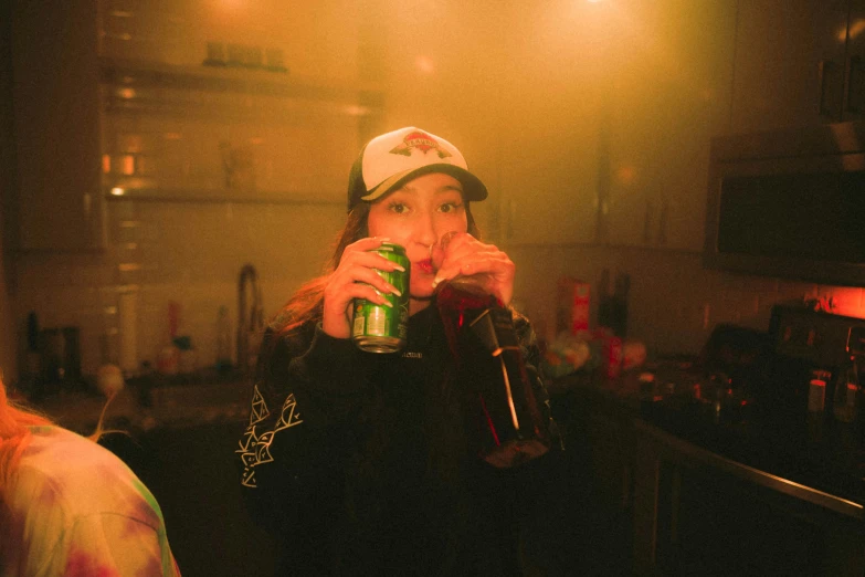 a woman in the kitchen drinking a cold beverage