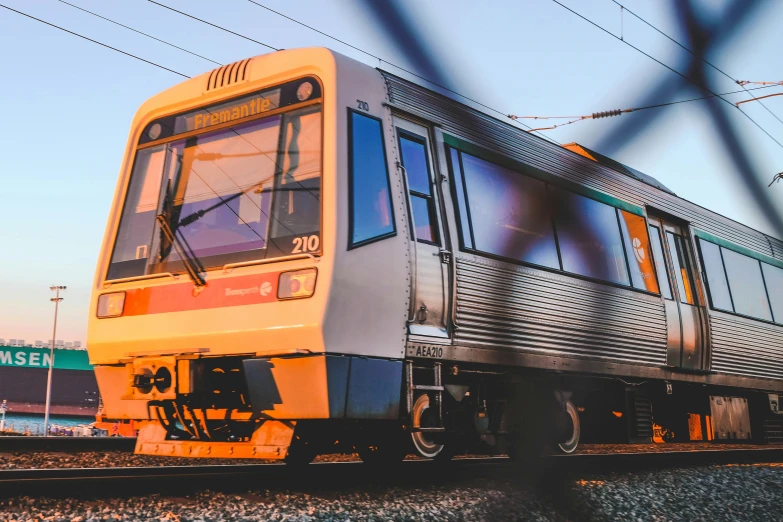 a colorful commuter train traveling down the tracks