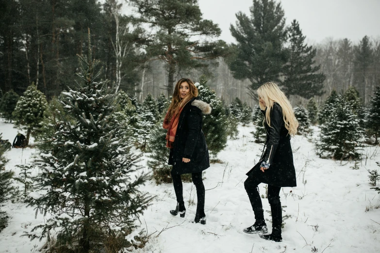 two women are dressed in all black and one is wearing red