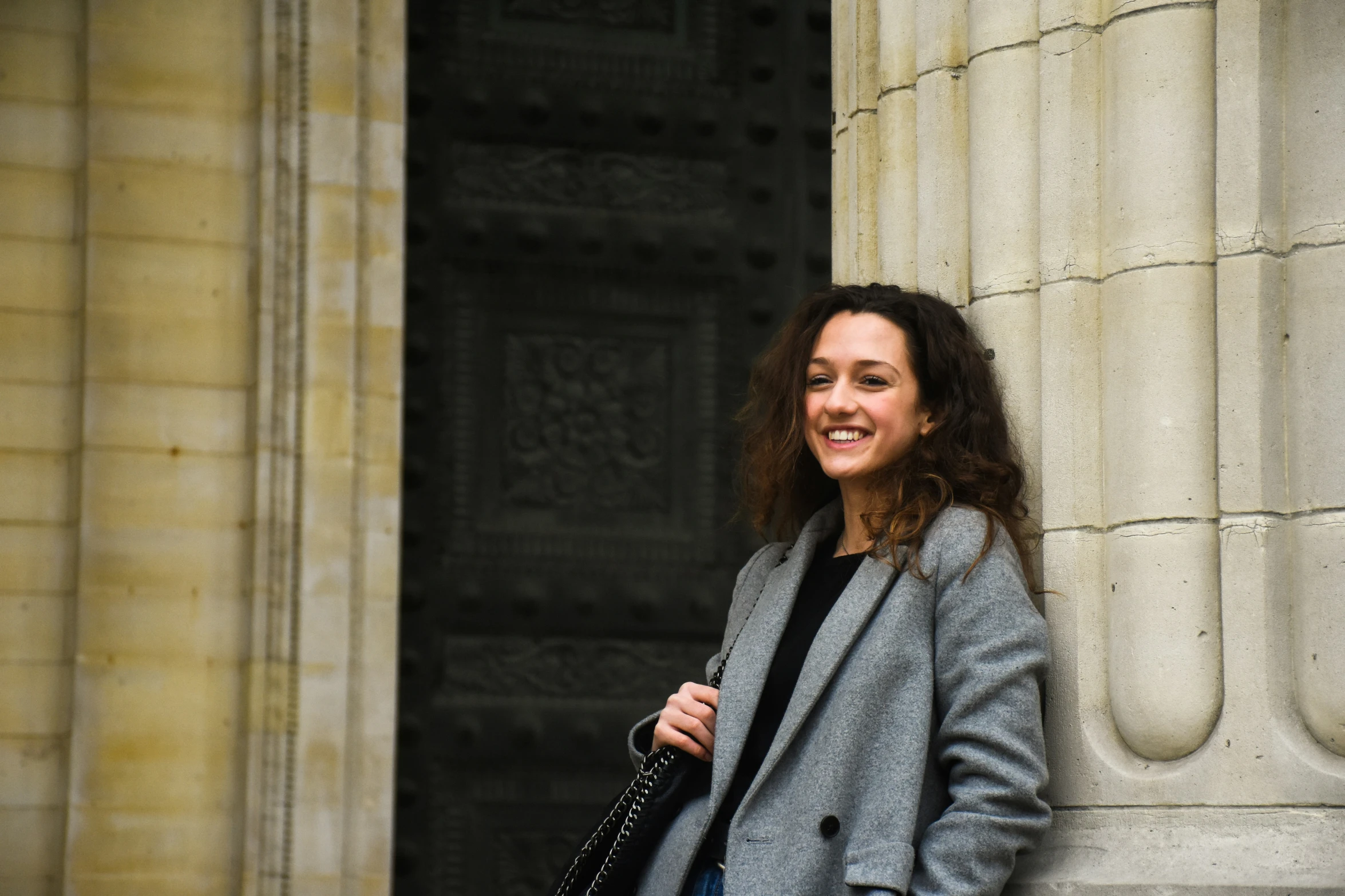 a woman standing in front of an old stone building