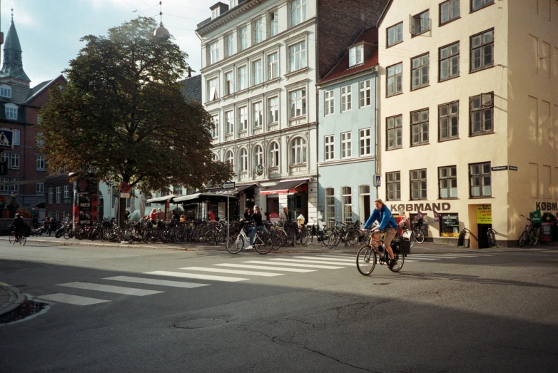 a group of people riding bicycles across a street