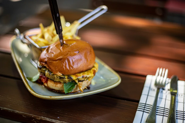 a cheeseburger on a plate with fries and a fork