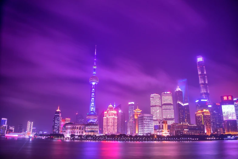 a view of the city of shanghai, china lit up in blue and pink