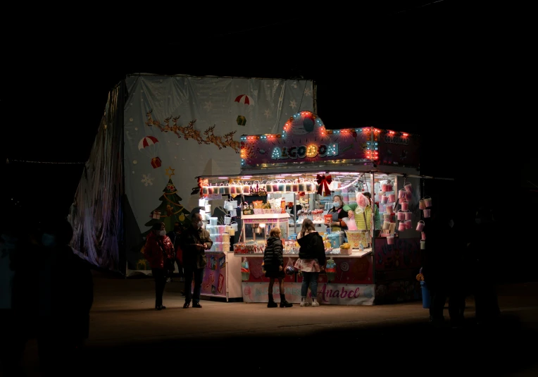 the silhouettes of people standing in front of a christmas market