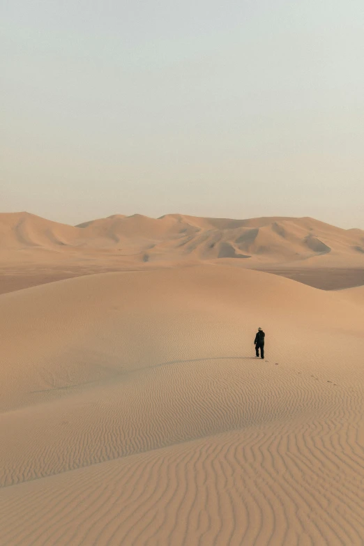 a lone figure is seen in the middle of a desert