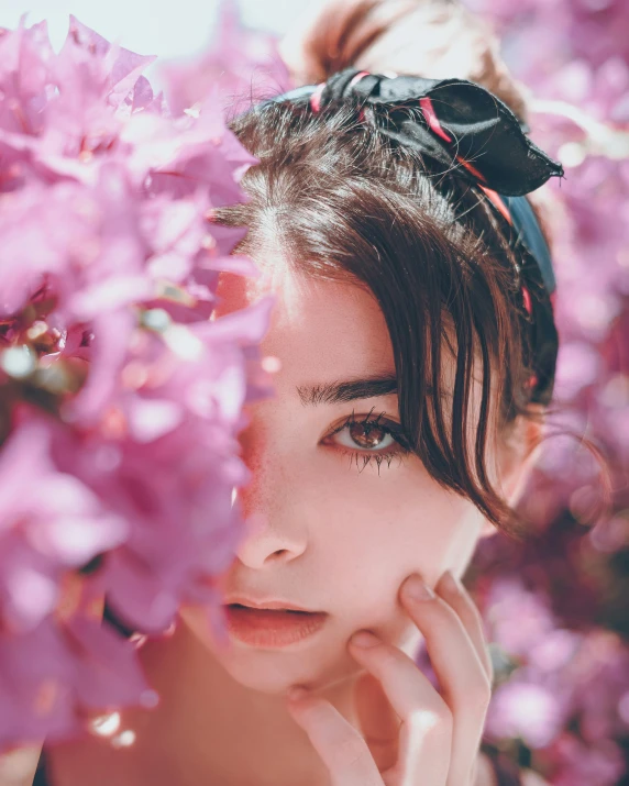 a woman with a bow around her head and purple flowers in her hair