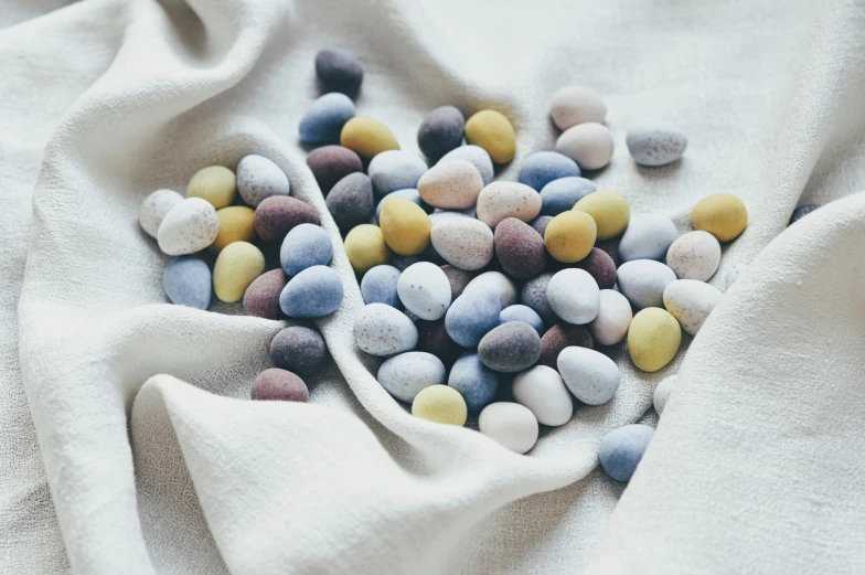 different colored rocks scattered on white cloth