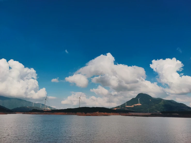 the clouds and mountains are all covering the water