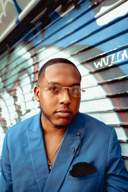 a man in a blue suit and clear glasses