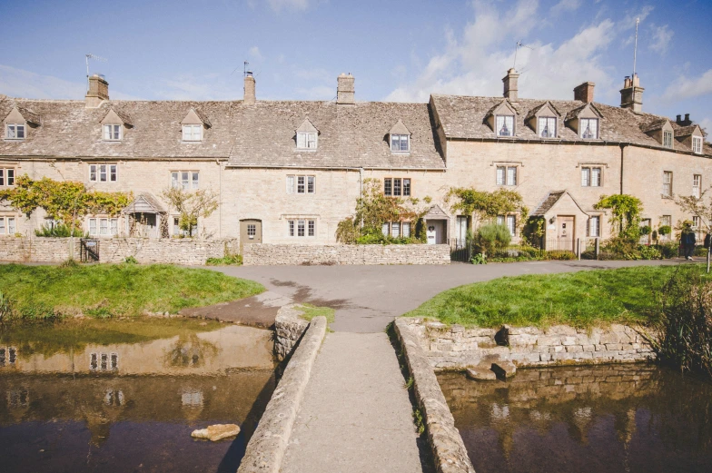 a long stone house with some water flowing in the front