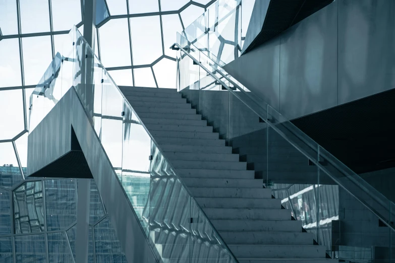 a white stair case next to glass walls