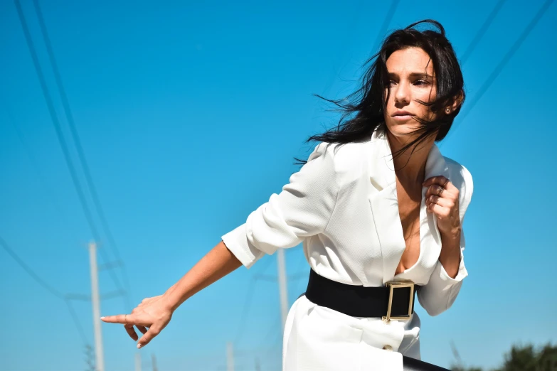 a woman in a white dress posing with her hands spread out