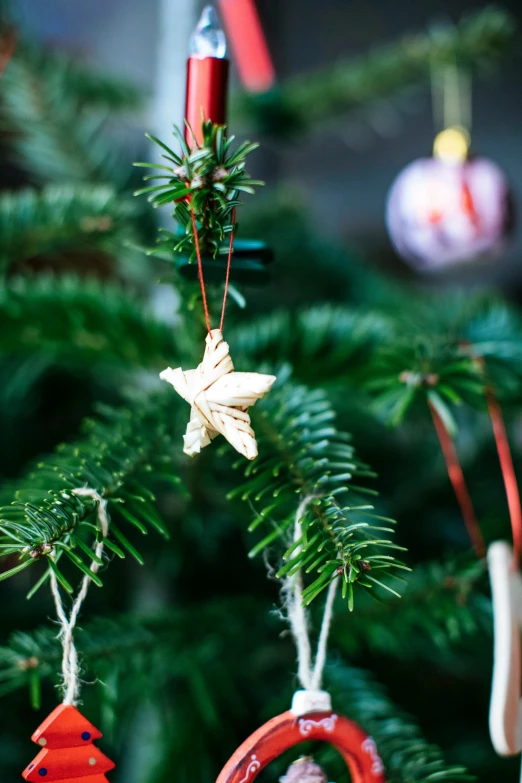 two wooden bells hang from a fir tree