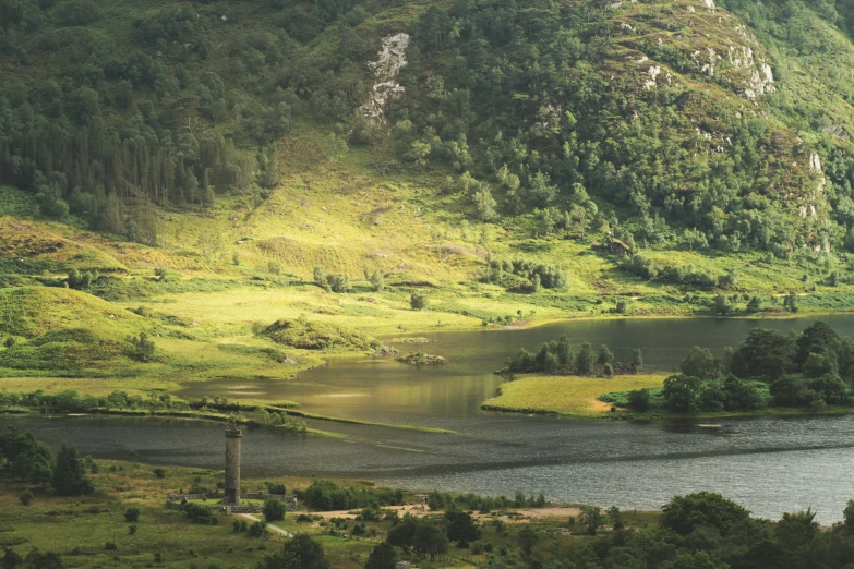 green mountains and forests surround a river surrounded by trees