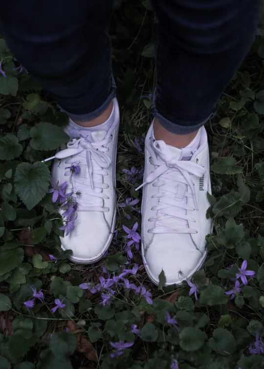 there is a white tennis shoe standing on the grass